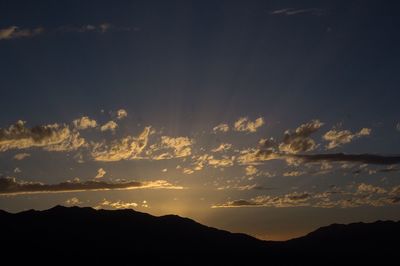 Scenic view of silhouette mountains against sky at sunset