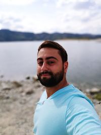 Portrait of smiling man against lake