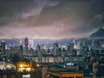 Illuminated cityscape against sky at night