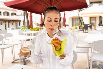 Woman holding ice cream in restaurant