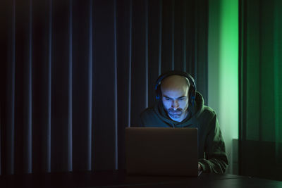 Man working on laptop in dark office