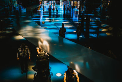 People walking in illuminated building at night