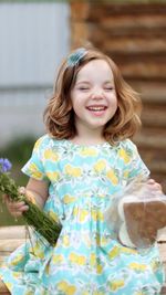 Cute little girl in autumn park holding bunch of yellow leaves