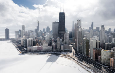 Aerial view of buildings in city against sky during winter