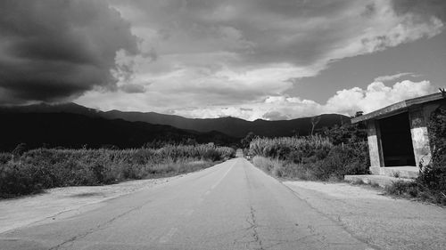 Empty road against cloudy sky