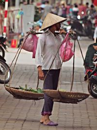 Full length of vendor standing on city street