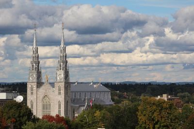 Panoramic view of buildings and trees against sky