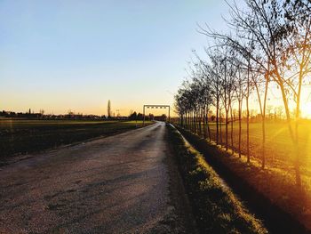 Empty road against sky during sunset