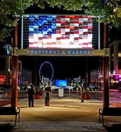 People on illuminated building at night