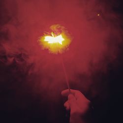 Low angle view of hand holding balloons