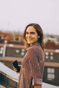 Portrait of smiling young woman standing outdoors