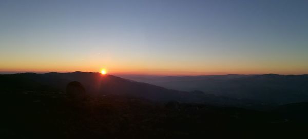 Scenic view of silhouette mountains against sky during sunset