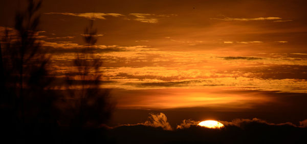 Silhouette of landscape against cloudy sky