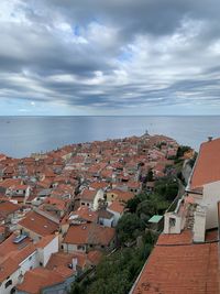 High angle view of townscape by sea against sky
