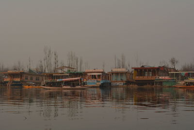 Boats moored in river against sky