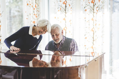 Senior couple playing piano together in nursing home