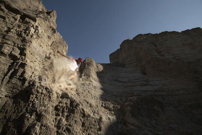 One man descending on a sandy and steep terrain at an old mining area