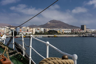 Sea and buildings in city against sky