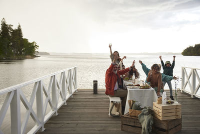 Family having dinner by lake and cheering