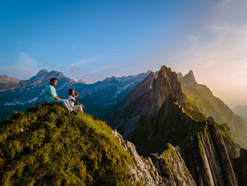 Panoramic view of woman and mountains against sky