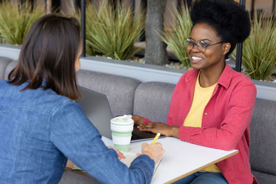 African american female student or freelancer in a public place talking to a colleague