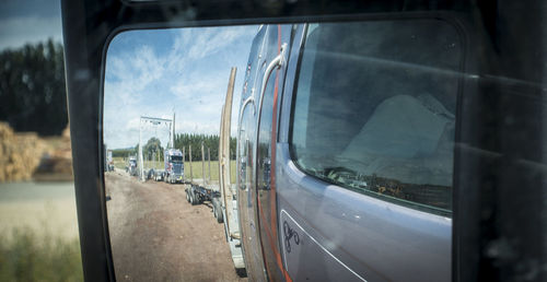 Reflection of man on side-view mirror at train