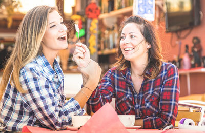 Portrait of smiling young woman sitting in restaurant