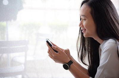 Side view of woman using mobile phone