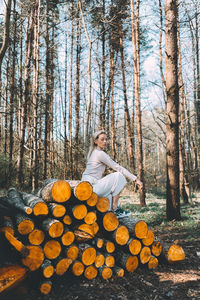 Man sitting on wooden logs in forest