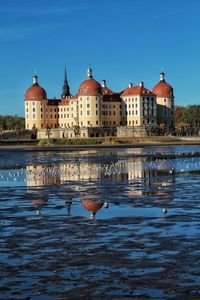 View of birds in lake against buildings