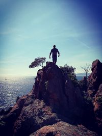 Statue of woman at beach against sky