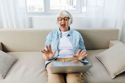 Portrait of young man using digital tablet while sitting on sofa at home