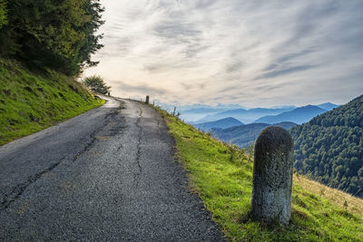 Road amidst field against sky