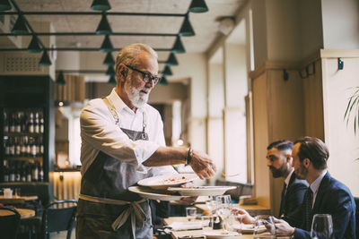 Waiter holding plates in restaurant