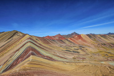 Scenic view of mountain range against blue sky