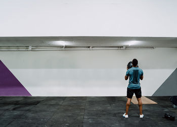 Rear view of man and woman standing against wall