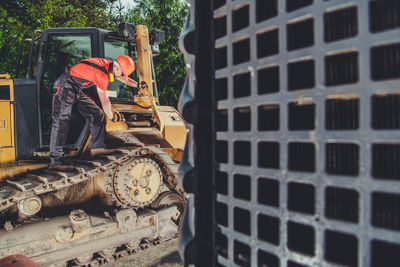 Construction worker repairing bulldozer