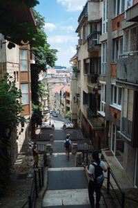 People walking on street amidst buildings in city