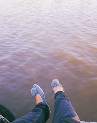 Low section of woman sitting over lake