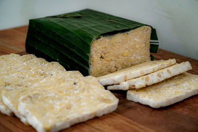 Close-up of bread and leaves on cutting board