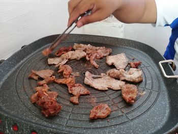 High angle view of person preparing food on barbecue grill