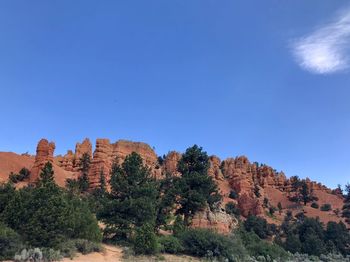 Low angle view of rocky mountain against blue sky