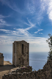 Old ruin building by sea against sky