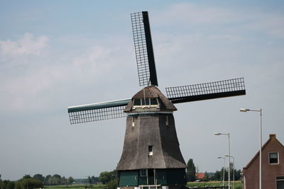 Low angle view of traditional windmill against sky