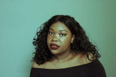 Portrait of young woman against gray background