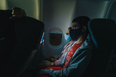 People wearing mask sitting in airplane