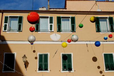 Low angle view of multi colored balloons hanging on building