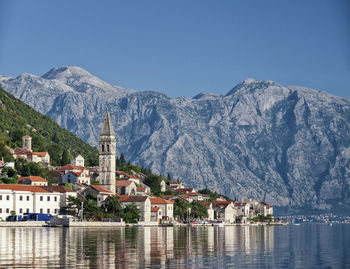 Town by buildings in mountains against clear sky