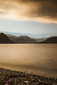 Scenic view of lake against cloudy sky