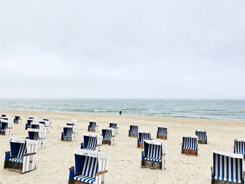 Chairs on beach against sky